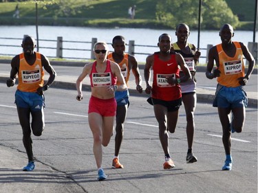 The top men runners, including the winner Wilson Kiprop (R), pass the women runners in the 10k race during the Ottawa Race Weekend on Saturday May 24, 2014. (Patrick Doyle / Ottawa Citizen)  ORG XMIT: 0526 ottawa10k19