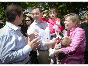 Progressive Conservative leader Tim Hudak, centre, along with his wife Deb Hutton and daughters Miller and Maitland speaks to PC candidate for Vaughan Peter Meffe, left, at a campaign stop in Woodbridge, Ontario May 24, 2014.