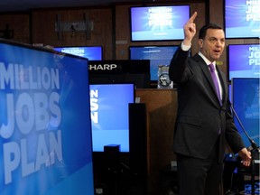 Ontario PC leader Tim Hudak is surrounded by his message as he speaks to the media at a campaign stop inside an electronics retail store in London, Ont., Thursday, May 15, 2014.