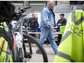 TIMESTAMP 11:02am The Ottawa Police Service celebrate Police Week with "Community Day" to showcase various Ottawa Police sections such as Marine, Dive and Trails (MDT), District Traffic (motorcycle demonstration), Tactical and Foot Patrol/Bicycle along Sparks Street Tuesday May 13, 2014. A pedestrian walks by members of the Tactical unit.