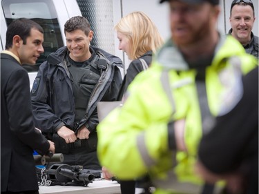 The Ottawa Police Service celebrate Police Week with "Community Day" to showcase various Ottawa Police sections such as Marine, Dive and Trails (MDT), District Traffic (motorcycle demonstration), Foot Patrol/Bicycle along Sparks Street Tuesday May 13, 2014. Jeremy House (left) of the Tactical Unit chats with pedestrians walking along Sparks Street Tuesday.