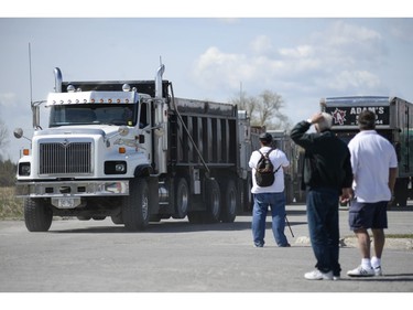 Trucks drive out of the Canadian Tire Centre parking lot where 147 Trucks and many supporters gathered to protest against the city on Saturday, May 10, 2014.