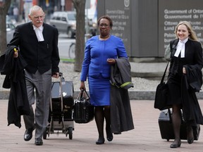 University of Ottawa law professor Joanne St. Lewis, centre, and her lawyer Richard Dearden, left, walk toward the Elgin Street courthouse on Thursday, May 15, 2014. St. Lewis is suing Denis Rancourt over remarks he made on a blog.