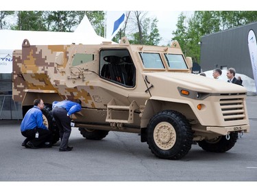 Visitors get a close up look at an armoured vehicle as the annual trade fair for military equipment known as CANSEC took place at the EY Centre near the airport. Photo taken at 09:16 on May 28, 2014.