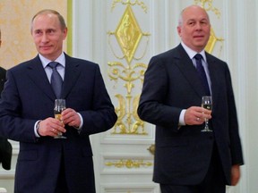 This April 20, 2009 file-pool photo shows Vladimir Putin, left, and state holding company Russian Technologies' head Sergei Chemezov, holding glasses after signing a deal in Moscow, Russia.