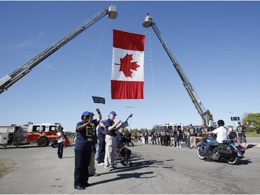 Volunteers cheer on motorcyclists at the Ottawa TELUS Motorcycle Ride for Dad at the Canadian Aviation and Space Museum on Saturday May 31, 2014.