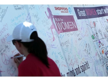 Women sign a banner following their run at the Shoppers Drug Mart Run for Women on Sunday, May 11, 2014 near the Aviation Museum. The 5K. 10K, and 1k for children helps raise money for Women's Mental Health programs in race cities, such as Royal Ottawa.  (Cole Burston/Ottawa Citizen)