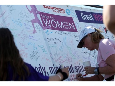 Women sign a banner following their run at the Shoppers Drug Mart Run for Women on Sunday, May 11, 2014 near the Aviation Museum. The 5K. 10K, and 1k for children helps raise money for Women's Mental Health programs in race cities, such as Royal Ottawa.