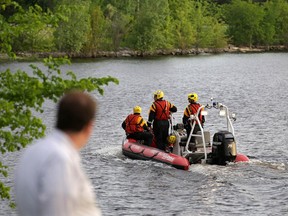 Ottawa fire boat searches along the shoreline near Deschenes Rapids in Ottawa.