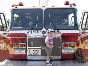 Massimo Pica (2) climbs on the fire truck on display at the seventh annual Touch a Truck fundraiser for Mothercraft at Lincoln Fields shopping centre on Sunday, June 1, 2014.