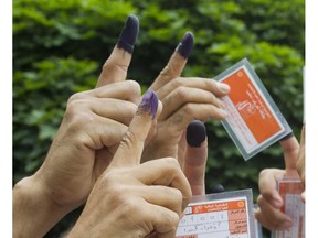 Members of Canada's Libyan community gathered to vote in a free election for the first time in 40 years in 2012. Voters show their ink stained fingers.