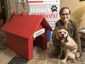 Real estate agent Peggy Blair and her dog Scout at the Royal LePage Team Realty office on Carling. Blair is the driving force behind Homes with Woofs!, a new fundraiser for the Ottawa Humane Society on June 12. The doghouse was built by Historic Building Company. (Pat McGrath / OTTAWA CITIZEN)