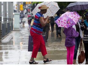 Pedestrians on Queen Street at Metcalfe on Tuesday, June 24, as warm wet weather with temperatures in the low 20's C with a chance of fog later in the evening.