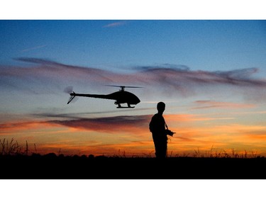 16 year-old Yanik Wolter controls a model helicopter during sunset on a field in Gleidingen near Hannover, northern Germany, Thursday, June 12, 2014. The small helicopter with up to 1.50 meters wingspan is remotely controlled. With top speeds of over 200 kilometers per hour, the model flyer steers the helicopter over secure meadows and cornfields.