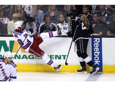LOS ANGELES, CA - JUNE 13:  Dustin Brown #23 of the Los Angeles Kings checks Dominic Moore #28 of the New York Rangers in the second period during Game Five of the 2014 Stanley Cup Final at Staples Center on June 13, 2014 in Los Angeles, California.