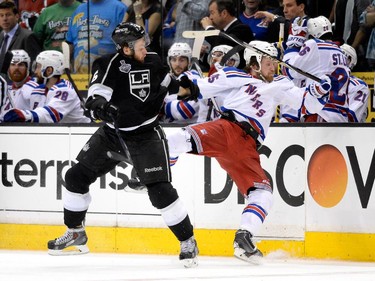 Jake Muzzin #6 of the Los Angeles Kings checks Derek Dorsett #15 of the New York Rangers in double overtime during Game Five of the 2014 Stanley Cup Final at Staples Center on June 13, 2014 in Los Angeles, California.