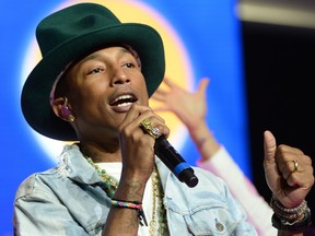 Pharrell Williams sings his song Happy at a meeting of Wal-Mart shareholders, where very unhappy employees attempted to oust the company chairman.  (Photo by Jamie McCarthy/Getty Images for Walmart)