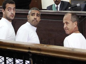 In this Monday, March 31, 2014 file photo, Al-Jazeera English producer Baher Mohamed, left, Canadian-Egyptian acting Cairo bureau chief Mohammed Fahmy, center, and correspondent Peter Greste, right, appear in court along with several other defendants during their trial on terror charges, in Cairo, Egypt.