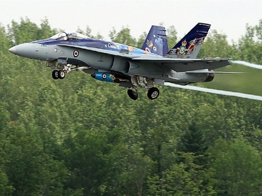 A CF -18, piloted by Captain Adam "Manik" Runge, flies low over the Gatineau Airport before landing for a Vintage Wings of Canada event Monday, June 30, 2014.