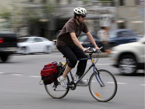 A cyclist rides along Laurier Ave. at intersection of Elgin St. in Ottawa, Thursday, May 15, 2014.