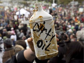 A demonstrator holds up a prop representing dirty oil during a mass sit-in in front of the British Columbia legislature in Victoria, B.C. Monday, Oct. 22, 2012. Protesters gathered to protest the proposed Northern Gateway pipeline.