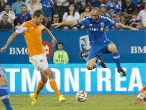 Montreal Impact's Marco Di Vaio, centre, and Houston Dynamo's Eric Brunner, left, and A.J. Cochran battle for the ball during second half MLS soccer action in Montreal, Sunday, June 29, 2014.