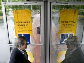 A man enters the Tudor Hall polling station near Riverside Drive in Ottawa on Thursday June 12, 2014