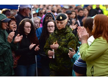 A member of the Canadian Forces takes part in a candlelight vigil outside RCMP headquarters in Moncton, N.B., on Friday, June 6, 2014. RCMP say a man suspected in the shooting deaths of three Mounties and the wounding of two others in Moncton was unarmed at the time of his arrest early Friday and was taken into custody without incident.