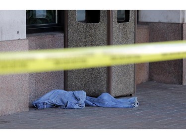 A pair of jeans lays on the sidewalk inside the tape near where police are investigating a fatal stabbing of an 18 year old man on Besserer Street, July 7, 2014.