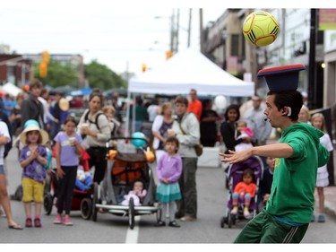 A street performer entertains a crowd along Richmond rd. in Westboro in Ottawa, during Westfest on Saturday, June 14, 2014.