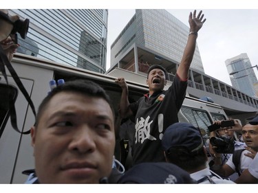 A villager shouts slogans as he is taken away by police officers after he hanged banners outside the Legislative building during a protest in Hong Kong Friday, June 13, 2014. Hundreds of villagers and students protest against the government on a development plan in the North Eastern New Territories.
