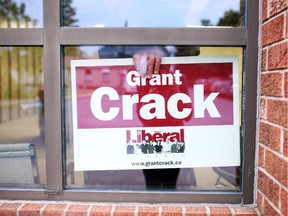 A volunteer puts up Grant Crack signage at Crack's election headquarters for the evening, on the election night in Alexandria, Ontario. (Cole Burston/Ottawa Citizen)