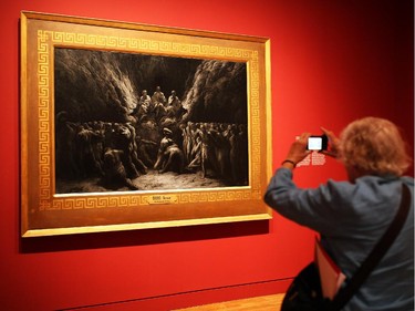 A woman takes a photo of a piece from the new Gustave Doré exhibit at the National Gallery of Canada on Wednesday, June 11, 2014.