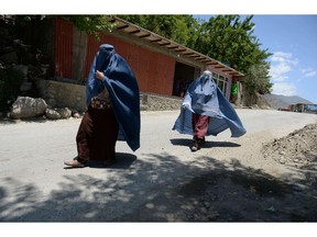 This file photograph taken on June 8, 2014 shows two burqa-clad Afghan women making their way in Bazarak district, Panjshir province. Getty photo.