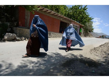 TO GO WITH Afghanistan-election-unrest-Panjshir,FOCUS by Edouard GUIHAIRE  In this photograph taken on June 8, 2014 two burqa-clad Afghan women make their way in Bazarak district, Panjshir province.  In the scenic Panjshir Valley where anti-Soviet fighter Ahmad Shah Massoud built his legend, all hopes are on his former spokesman Abdullah Abdullah to win the June 14 run-off presidential election and pursue his legacy.