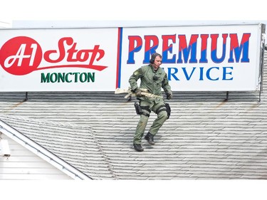 An Emergency Response Team member walks on the roof of a house in Moncton, N.B., Thursday, June 5, 2014 as the search for a heavily armed gunman suspected to have shot three Mounties dead and injured two others continues.