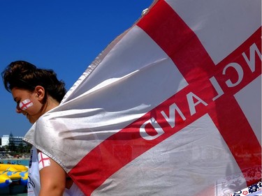 An English soccer fan in Cyprus holds an England flag on "Nissi Beach" in the famous southeastern coastal resort of Ayia Napa, Cyprus, Saturday, June 14, 2014.  England will play today against Italy in 2014 World Cup in Brazil.