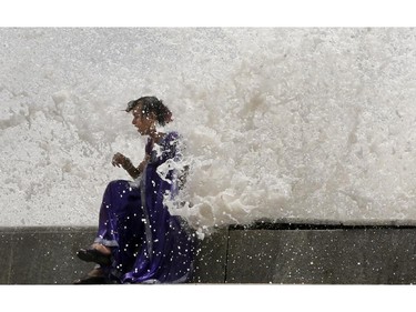 An Indian eunuch enjoys high tide waves on the Arabian Sea coast in Mumbai, India, Friday, June 13, 2014. According to local reports, the city would witness high tides measuring 4.5 meters (15 feet) till Wednesday. Eunuch is the term used in India to describe a community of people who identify themselves as neither male nor female but as members of a third gender.