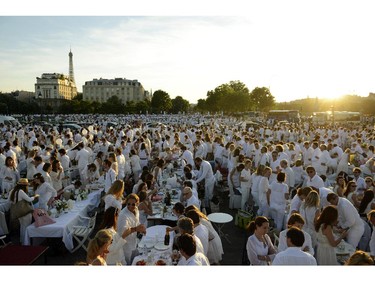 PARIS, FRANCE - JUNE 12:  People attend the 26th Diner en Blanc outdoor picnic event on the Alexander III Bridge on June 12, 2014 in Paris, France. The event, which organizers estimated between 12,000 and 13,000 people participated, took place over six bridges throughout Paris and has spread to more than 40 cities around the world.