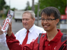 0628 byelections4: Arnold Chan, the Liberal candidate in Scarborough-Agincourt, waves to commuters with former Ontario Liberal minister Gerry Phillips on June 25. Chan is trying to succeed long-time Liberal MP Jim Karygiannis to keep the riding in northeastern Toronto painted red.