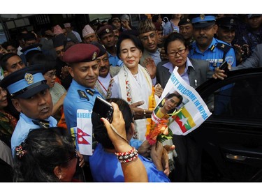 Myanmar�s pro-democracy leader Aung San Suu Kyi, center, arrives at Nepalese Tribhuwan International Airport in Katmandu, Nepal, Friday, June 13, 2014. Suu Kyi arrived in Nepal Friday to attend a democracy conference, meet top political leaders and visit Buddhist pilgrimage sites.