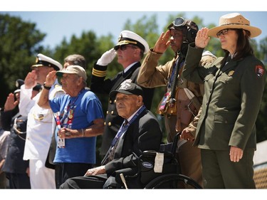 WASHINGTON, DC - JUNE 06:  American World War II veteran Henry Mendoza (seated) of Rancho Cucamonga, California, is joined by National Park Service Deputy Superintendent of Operations Karen Cucurullo (R), NPS historian John McCaskill and others during the 70th anniversary D-Day commemoration at the WWII Memorial on the National Mall June 6, 2014 in Washington, DC. Mendoza was a member of the U.S. Army 9th Air Force and gave air support to the invasion of Normandy by allied troops.