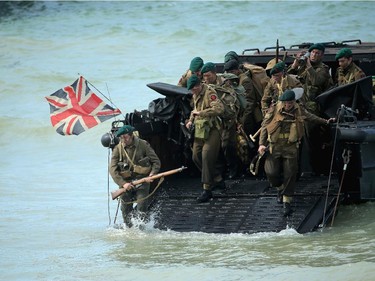 ARROMANCHES LES BAINS, FRANCE - JUNE 06:  Re-enactors storm Gold Beach from a Royal Marine Landing craft during the 70th anniversary of the D-Day landings parade on June 6, 2014 in Arromanches Les Bains, France.  Friday 6th June is the 70th anniversary of the D-Day landings which saw 156,000 troops from the allied countries including the United Kingdom and the United States join forces to launch an audacious attack on the beaches of Normandy, these assaults are credited with the eventual defeat of Nazi Germany. A series of events commemorating the 70th anniversary are planned for the week with many heads of state travelling to the famous beaches to pay their respects to those who lost their lives.