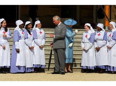 Britain's Prince Charles, Prince of Wales, president of the British Red Cross with Princess Alexandra (R), deputy president, pose with nurses dressed in World War 1 uniform during a garden party in the grounds of Buckingham Palace in central London, on June 12, 2014 in honour of the British Red Cross.