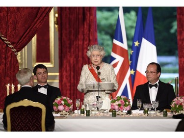 Britain's Queen Elizabeth II, center, delivers a speech as French President Francois Hollande, right, looks on at the start of a state dinner at the Elysee presidential palace in Paris, Friday, June 6, 2014, following the international D-Day commemoration ceremonies in Normandy, marking the 70th anniversary of the World War II Allied landings in Normandy.