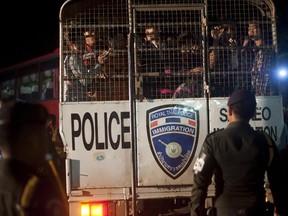 Cambodian workers wait to get off an Immigration Thai police truck after they cross the Thai border on June 17, 2014 in Poipet, Cambodia. The Guardian recently reported that some Thai police demand bribes of migrants or hand them to slave brokers.