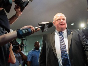 Toronto Mayor Rob Ford leaves his office at city hall in Toronto on June 30 amid a crush of cameras.