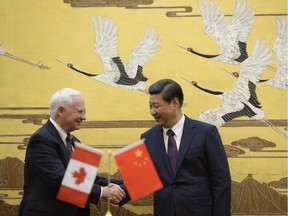 Chinese President  Xi Jinping (R) welcomes Governor General David Johnston of Canada at the Great Hall of the People on October 18, 2013 in Beijing, China.