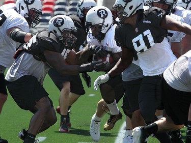 Chevron Walker holds onto the ball during a tackling practice. The Ottawa Redblacks held their first practice ever at the new TD Place stadium at Lansdowne Park Friday, June 27, 2014.