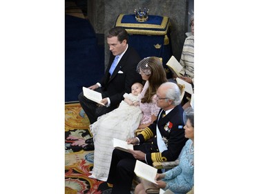 Christopher O'Neill, left, Princess Leonore, on her mother's lap, Princess Madeleine, King Carl XVI Gustaf of Sweden, 2nd right and Queen Silvia, right, sit during Princess Leonore's christening in the Drottningholm Palace church outside Stockholm, Sweden, Sunday, June 8, 2014.